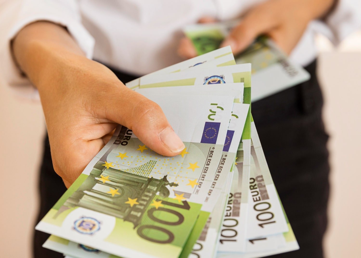 main présentant plusieurs billets d’euros liés à des aides à Cabourg