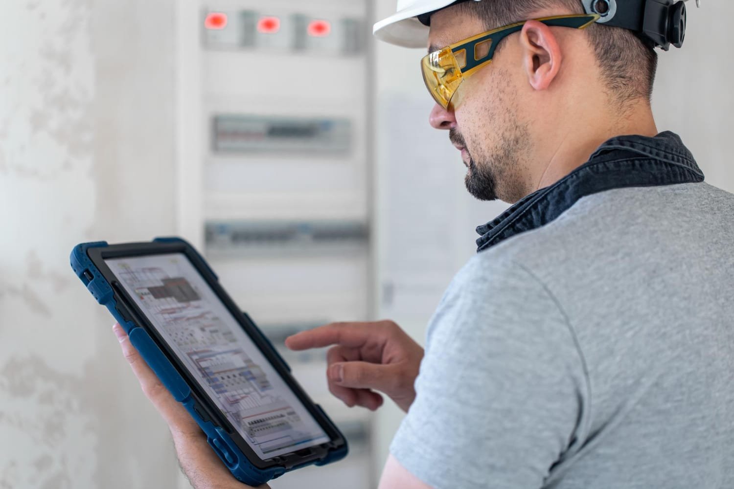 électricien utilisant une tablette devant un coffret à Cabourg