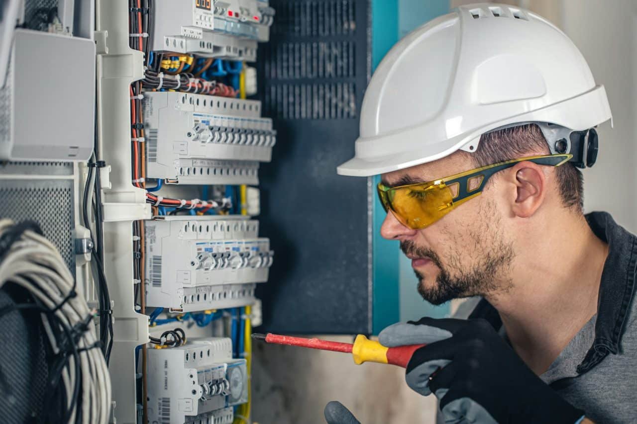 technicien vérifiant des disjoncteurs dans un coffret électrique à Cabourg